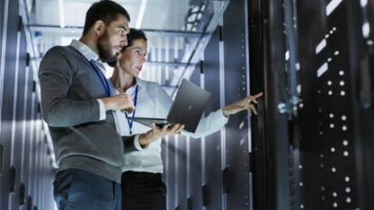 A man and a woman look at a high tech digital screen